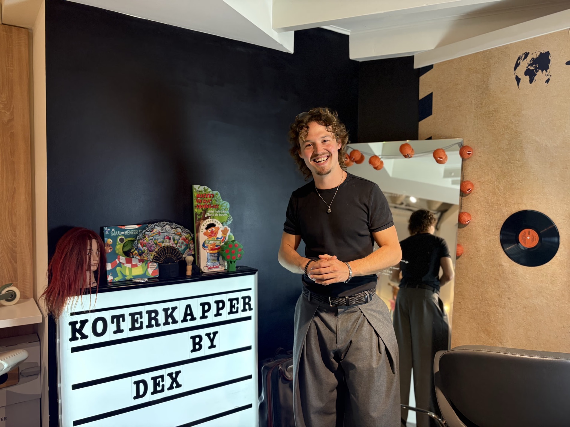 Dex in zijn kapperszaak Koter Kapper bij Magasine in Laren, naast de verlichte letterbak met KOTERKAPPER BY DEX
